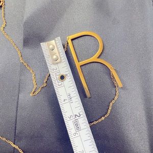 Large “R” initial necklace in yellow gold. Unknown metal.